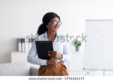 Psychological education concept. Confident black business coach giving professional growth training at office. Motivated young tutor teaching personal development course, indoors Royalty-Free Stock Photo #1996266119