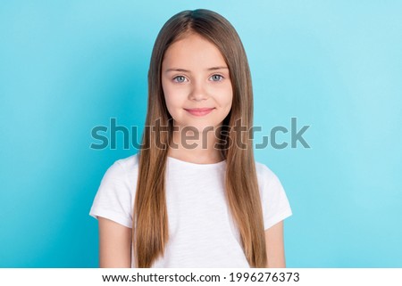 Photo of nice brown hair small girl wear white t-shirt isolated on blue color background