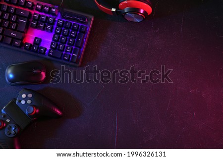 Modern RGB keyboard, mouse and video game controller on grey table, flat lay. Space for text