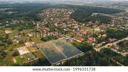 Marked vacant land for construction and sale. The concept of selling land and residential real estate on the land market is an aerial shot with overlay. Royalty-Free Stock Photo #1996331738