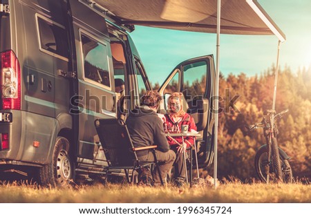 Caucasian Couple Playing Chess Next to Their Camper Van RV During Vacation Camping Time. Recreational Vehicles and Road Trip Theme. Royalty-Free Stock Photo #1996345724