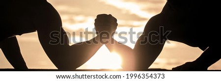 Rivalry, closeup of male arm wrestling. Men measuring forces, arms. Two men arm wrestling. Rivalry, vs, challenge, hand wrestling. Sunset sunrise.