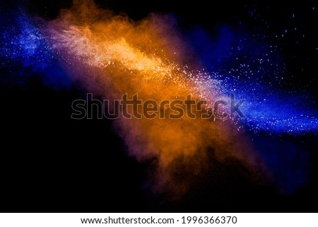 Orange blue  powder explosion on black background.Orange blue color dust splash clouds.