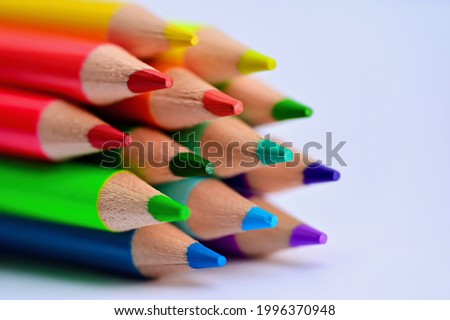 Several pens in rainbow colors against white background