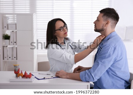 Doctor examining thyroid gland of patient in hospital Royalty-Free Stock Photo #1996372280