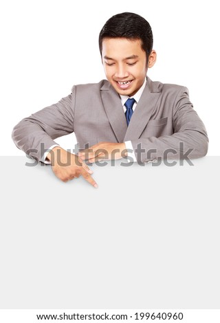Young businessman pointing at a blank board, isolated on white background