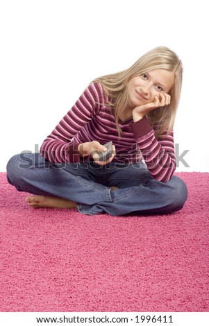 isolated on white young blonde woman sitting on the pink carpet with remote control