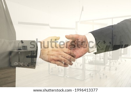 Double exposure handshake of two businessmen on modern furnished office interior background, collaboration and coworking concept