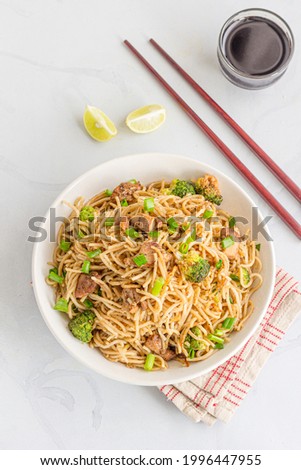 Chicken Chow Mein in a Bowl with Soy Sauce and Lemon Vertical Photo