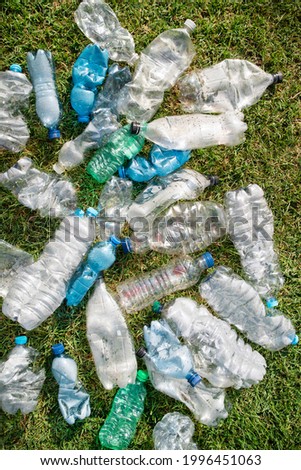 Sign of incivility used plastic bottles abandoned in a meadow 