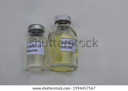 Coronavirus Covid-19 vaccine concept. Small glass vial with lid, white table top (custom design sticker with mockup. not the real product)