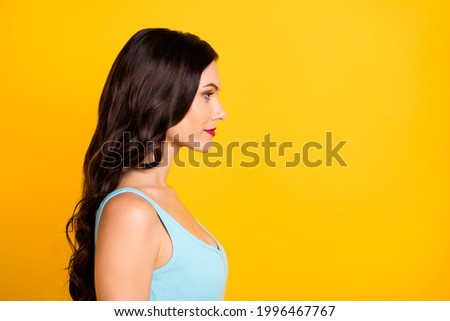 Profile photo of calm charming young girl look empty space wear blue top isolated yellow color background