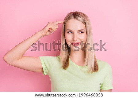Photo of minded cunning lady finger head tricky look side empty space wear green t-shirt isolated on pink background Royalty-Free Stock Photo #1996468058
