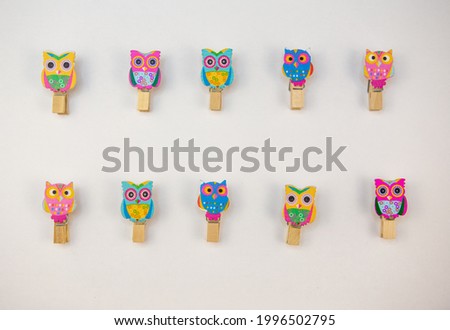 ten wooden owl pegs on a white background