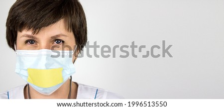 Truth About 2019 Novel Coronavirus 2019-nCoV . Medical secrecy concept. Woman doctor with taped lips in white uniform on white background. Pandemic. Panic. Information