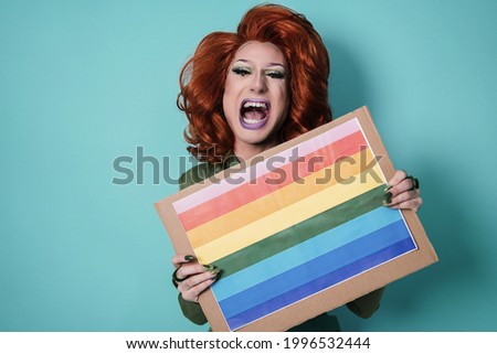 Happy drag queen holding rainbow flag banner - Lgbt concept - Focus on face
