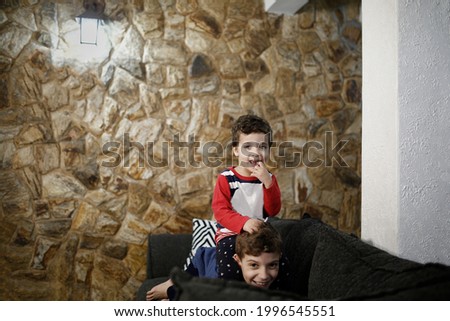 brothers playing on the sofa at home smiling