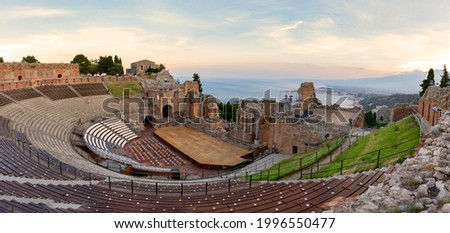 Ruins of ancient Greek theater in Taormina and Etna volcano in the background. Coast of Giardini-Naxos bay, Sicily, Italy, Europe.

