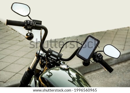 motorcycle with electronic dashboard gps on the steering wheel. mobile phone in cover. 