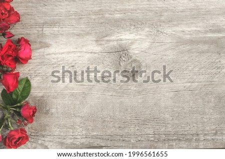 Vintage gray wood background with bright roses and copy space