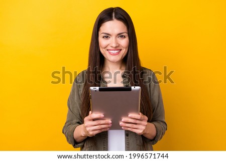 Photo of sweet charming young woman wear khaki outfit smiling typing modern gadget isolated yellow color background