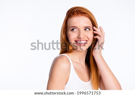 Photo of young cheerful girl happy positive smile hand touch hair look empty space isolated over grey color background