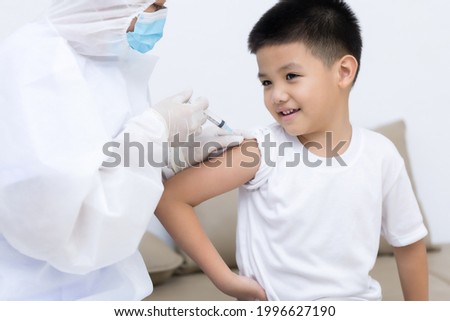 Doctor vaccinating Asian little boy at doctor's office