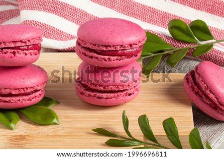 A pile of pink macaroons with raspberry