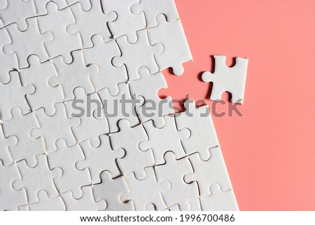 Jigsaw puzzle with missing piece. Missing puzzle pieces. Concept image of unfinished task. Completing final task, missing jigsaw puzzle pieces and business concept with a puzzle piece missing. pink