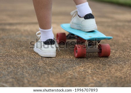View of Young Girl standing on a Skateboard