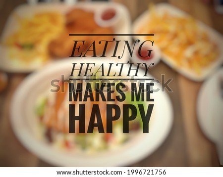 Inspirational quote of eating healthy "EATING HEALTHY MAKES ME HAPPY" isolated on a blurry food background.
