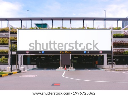Blank advertising large billboard banner mockup, outside multi-storey carpark with eco green wall, above entrance. Large digital display screen, an out-of-home OOH media display space Royalty-Free Stock Photo #1996725362