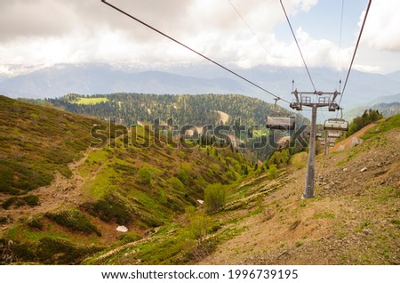 Summer landscape-view of the Edelweiss chairlift with funiculars, mountains and forest. Rosa Khutor, Sochi, Russia