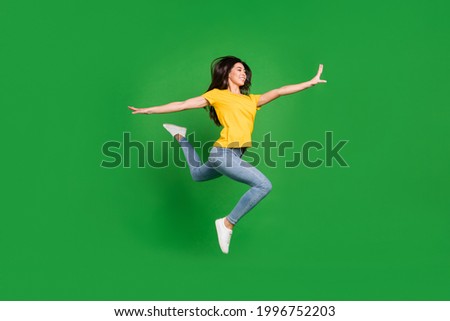 Full length photo of cheerful happy active young woman jump up flexible lady isolated on green color background