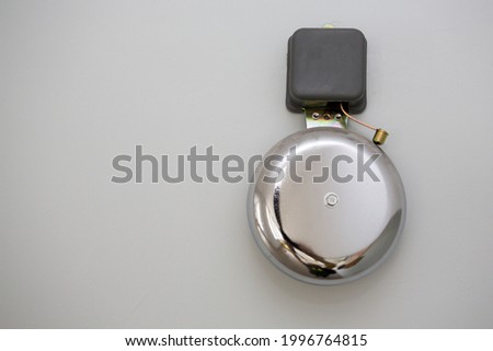  Metal school bell over grey wall Royalty-Free Stock Photo #1996764815