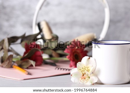 a mug of tea is on the table next to the items for the office