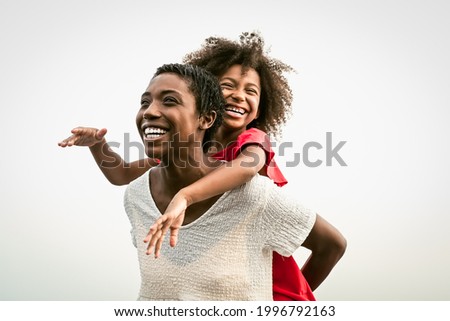 Happy African family on the beach during summer holidays - Afro people having fun on vacation time - Parents love and travel lifestyle concept Royalty-Free Stock Photo #1996792163