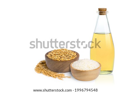 Rice bran oil extract in glass bottle with white rice and paddy rice isolated on white background. Copy space for text. Royalty-Free Stock Photo #1996794548