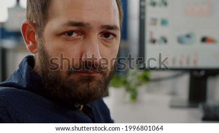 Invalid handicapped disabled business manager immobilized in wheelchair looking tired at camera working in economic business company at computer prosessing financial information monitoring economy