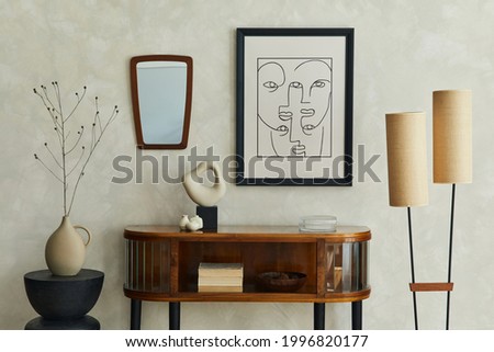 Stylish composition of creative living room interior with mock up poster frame, wooden commode, lamp, mirror, dry banch in vase and elegant personal accessories. Neutral beige wall. Template.

