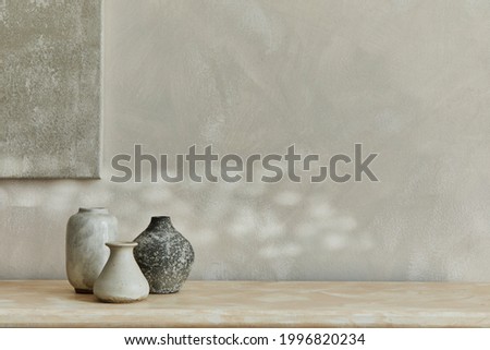 Stylish minimalistic monochromatic composition with design vases and personal accessories. Poster on the wall, copy space. Neutral colors. Template. 