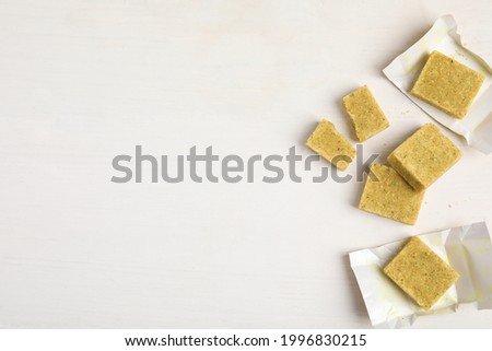 Bouillon cubes on white wooden table, flat lay. Space for text