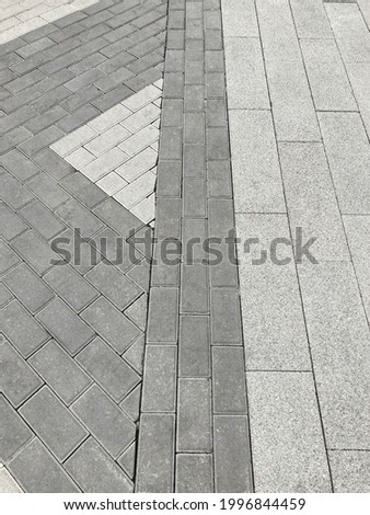 Sidewalk from different types of paving stones in one place