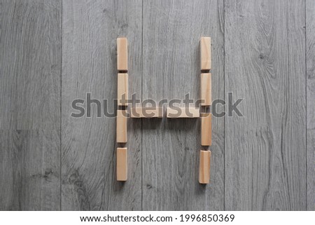 letter H with wooden natural blocks, construction , game for kids , no stress with wooden blocks, background