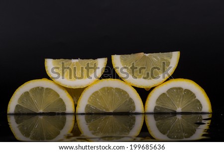 Lemon slices with reflection, black background, isolated