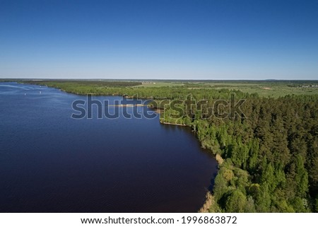 Top view of the lake and the shore of the earth, the skyline of the sky on a bright sunny day. Beautiful summer landscape, picture from the drone.