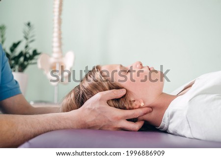 A girl receiving CST treatment, Osteopathic Manipulation and CranioSacral Therapy for children Royalty-Free Stock Photo #1996886909