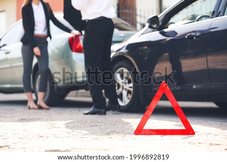 Emergency stop sign near broken cars after accident on road