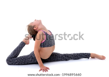 Little girl schoolgirl, performs gymnastic twine.