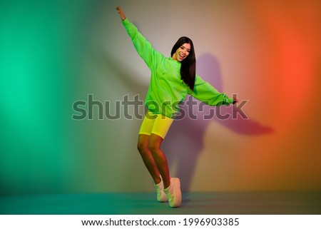 Full length body size view of pretty cheerful girl dancing posing having fun isolated over multicolor vivid neon light background